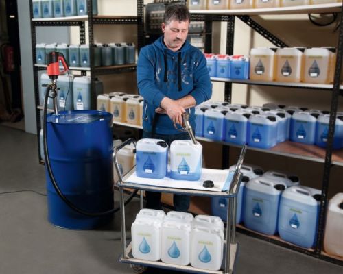 Man filling Ad Blue containers with drum pump and hand nozzle