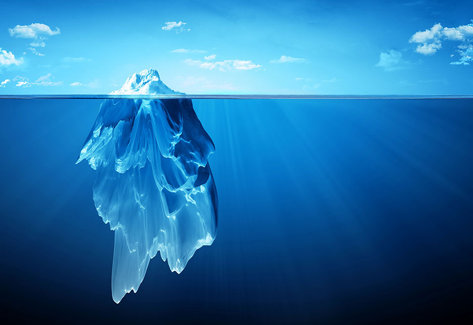 Picture of the tip of an iceberg surfacing the ocean